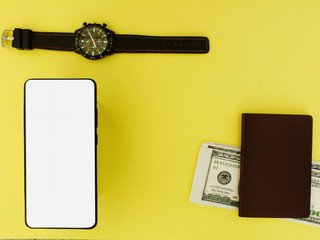 The white screen smartphone with a top $ 100 bank note and a yellow background calculator top view