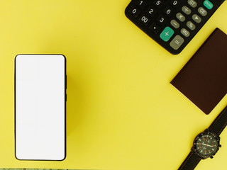 White screen smartphone with calculator and watch on a yellow background