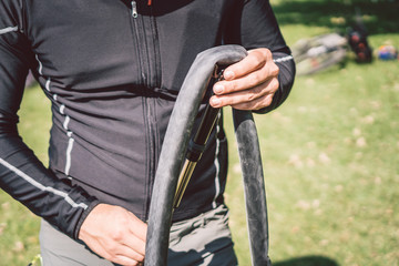 Bike Repair. Man Repairing Mountain Bike. Cyclist man in trouble rear wheel wheel case of accident. Man Fixes Bike near lake in Italy background mountains. cyclist repairing bicycle wheel outdoors