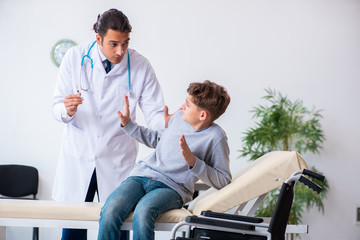 Young male doctor pediatrist and boy in wheel-chair © Elnur