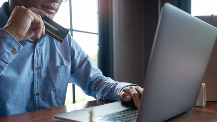 Man paying with credit card and entering security code for online shopping making a payment or purchasing goods on the internet with laptop computer, online shopping concept