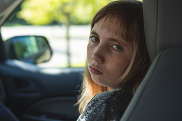 Sad/Depressed teen girl sitting in a car/suv while being driven to/picked up from school.