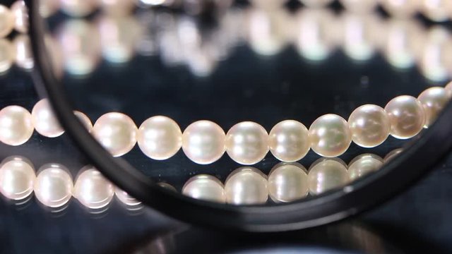 真珠のネックレスと拡大鏡