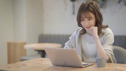 カフェでノートパソコンを操作している女性	
