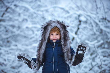 Fototapeta na wymiar Winter landscape of forest and snow with cute child boy. Enjoying nature wintertime. Happy winter time. Active winter children concept.
