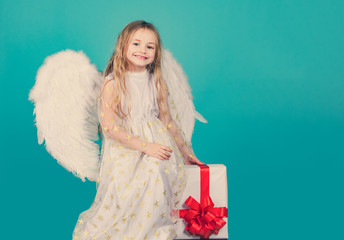 Valentines Day. Angel child from heaven gives you gift. Face of beautiful little angel girl on...