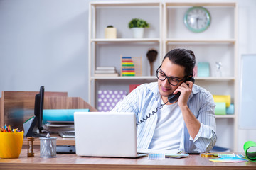 Obraz premium Young male designer working in the office
