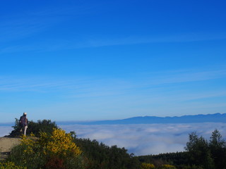 Obraz premium Amazing sea of clouds with Pilgrim on the road to Santiago de Compostela, Camino de Santiago, Way of St. James, Journey from Foncebadon to Ponferrada, French way, Spain