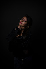 Fashion portrait of an young and attractive Indian Bengali brunette girl with black western dress in front of a black studio background. Indian fashion portrait and lifestyle.