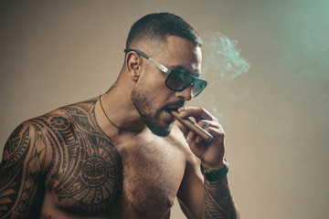 Attributes of men power, strength and luxury life. Strong confident tattooed man in luxury...