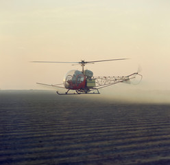 helicopter crop dusting in morning