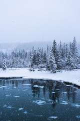 Canada Landscape. View of snow covered mountain scenery, Bow river and Three Sisters in winter. Beautiful snowy day in Canadian Rockies. Canmore, Alberta, Canada.
