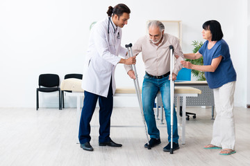 Old couple visiting young male doctor