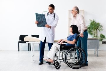 Old couple visiting young male doctor