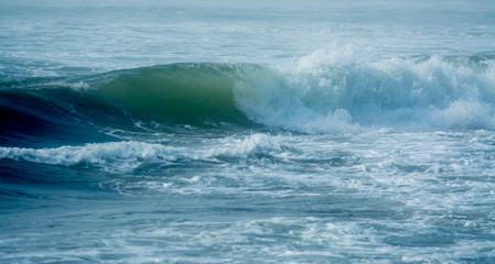 Massive waves crashing in ocean .