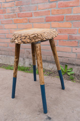 Wooden stool, handmade chair on a background of red brick wall