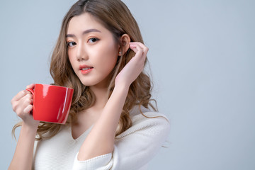 attractive asian beautiful female woman hand hold hot cup coffee drink look at camera portrait studio shot white background