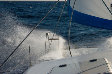 Sailing in strong wind with crashing waves on deck
