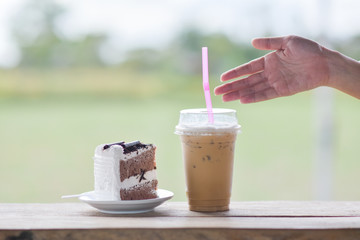 People drink ice coffee in cafe with coconut cake,Ice coffee on wood table