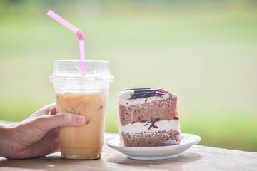 People drink ice coffee in cafe with coconut cake,Ice coffee on wood table