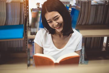 Young woman reading a book at the library