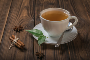 Freshly made tea in a white Cup with cinnamon on a wooden table.