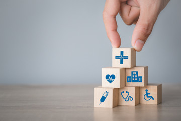 Health Insurance Concept,hand arranging wood block stacking with icon healthcare medical.