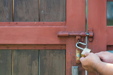 Male hand unlock red grunge vintage steel and wood door