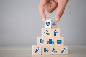 Health Insurance Concept,hand arranging wood block stacking with icon healthcare medical. - obrazy, fototapety, plakaty