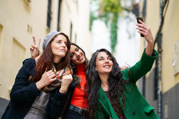 Group of three happy woman walking together outdoors
