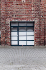 Large garage door with brick wall and asphalt driveway