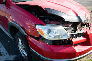 Front of red car get damaged by accident on the road