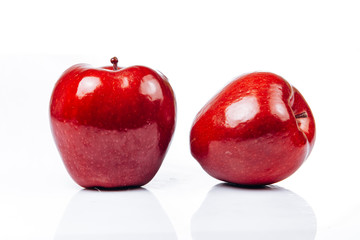 A few fresh red apples on a white background with a beautiful reflection