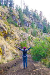 A woman enjoys nature with arms wide open