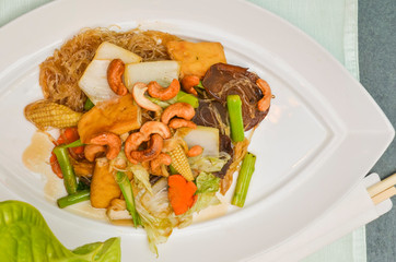 Vegetarian food stir-fried vermicelli in a white plate on the table