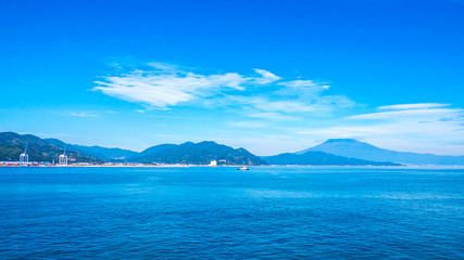 Landscape view of Fuji Mountain over blue sky and white cloud from the ferry boat in the ocean at Suruga Bay, Shizuoka, Japan