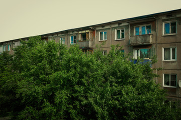 Soviet apartment building. Apartment block. Soviet architecture. Ust-Kamenogorsk (Kazakhstan). Concrete apartment building. Grunge. Windows and balconies. Closeup detailed fragment