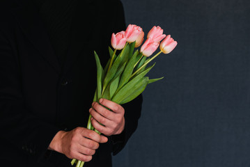 bouquet of pink tulips in the hands of a man