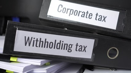 Stack of taxes binders report concept: Document of Withholding tax and corporate tax for accountant. withholding tax sometimes applies to royalties, rent or even sale duty must be paid to government