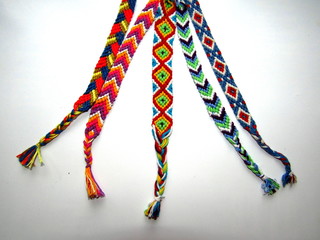 friendship bracelets made of thread with braids on white background	
