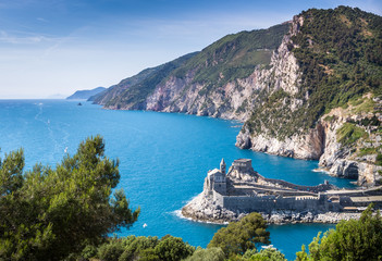 Porto Venere (Portovenere), Liguria, Italy: beautiful aerial scenic view of the Church of St. Peter (Chiesa di San Pietro) from Palmaria Island nearby Cinque Terre with Byron grotto - obrazy, fototapety, plakaty
