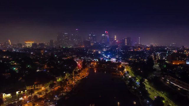 Aerial time Lapse of fireworks over Echo Park in the city of Los Angeles close to downtown LA at night with view of Los Angeles Skyline and office buildings.