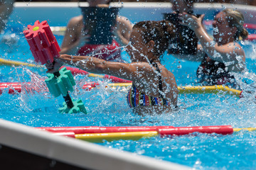 Girls Doing Water Aerobics with Floating Pool Dumbbells Outdoor in a Swimming Pool