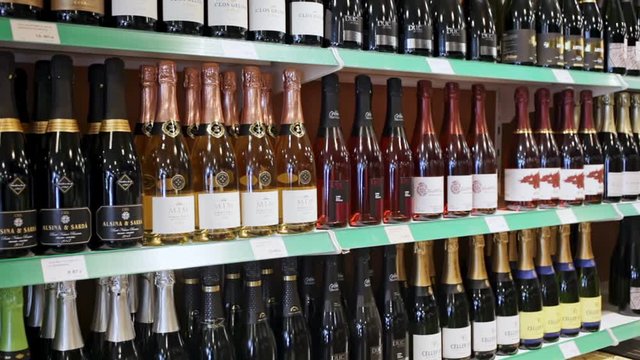 BARCELONA, SPAIN - NOVEMBER 07, 2019: Rows of cava bottles, traditional spanish sparkling wine on shelves in wine store