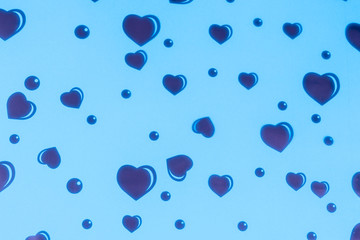 Red hearts of different sizes on a blue background with reflections.