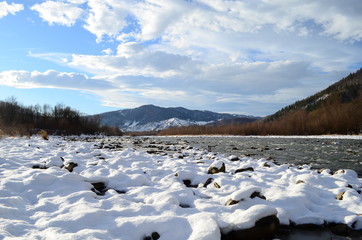 winter landscape in the forest with snow and blue sky and river