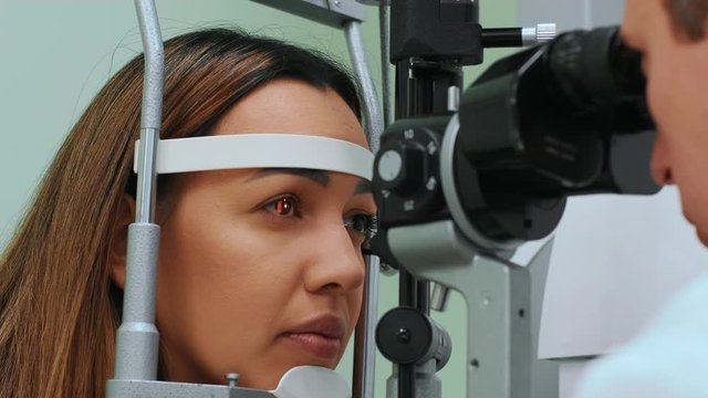 Eyes measured with refractometer at optician or ophthalmologist. Ophthalmologist measuring intraocular pressure of young woman in clinicogist measuring intraocular pressure of young woman in clinic