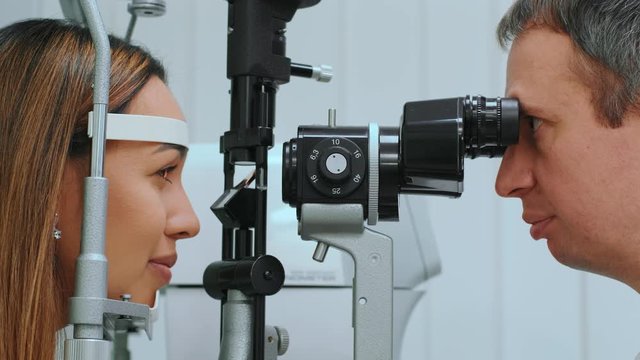 Eyes measured with refractometer at optician or ophthalmologist. Ophthalmologist measuring intraocular pressure of young woman in clinicogist measuring intraocular pressure of young woman in clinic