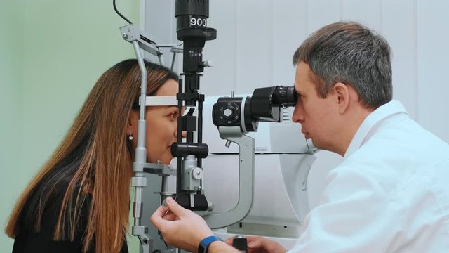 Eyes measured with refractometer at optician or ophthalmologist. Ophthalmologist measuring intraocular pressure of young woman in clinicogist measuring intraocular pressure of young woman in clinic