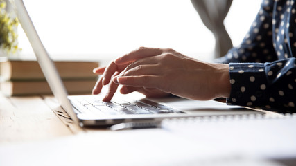 Female professional student using laptop at desk, close up view